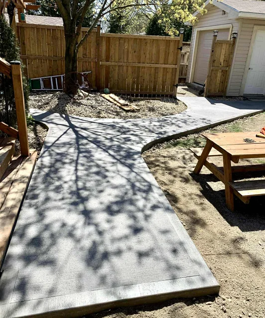 Expert decorative concrete flatwork — smooth slab patio and curved walkway installation